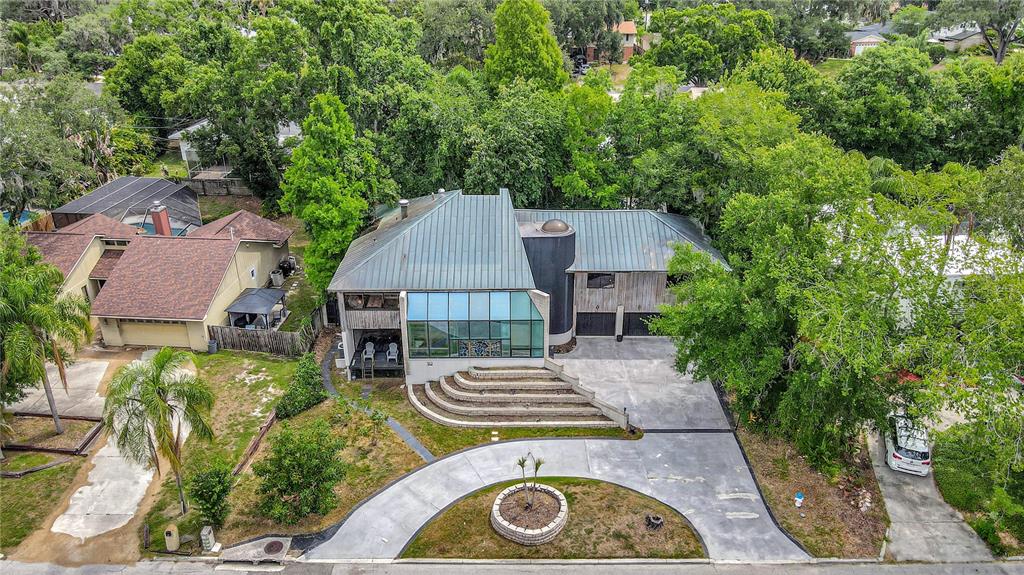 An aerial view of a house with a metal roof, glass facade, and curved driveway — 312 S RIVERHILLS DRIVE, TAMPA, FL