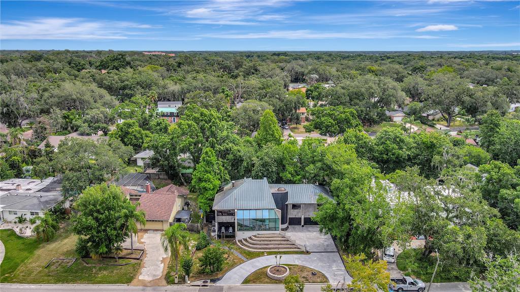 An aerial view shows a modern house with a metal roof and large glass windows — 312 S RIVERHILLS DRIVE, TAMPA, FL