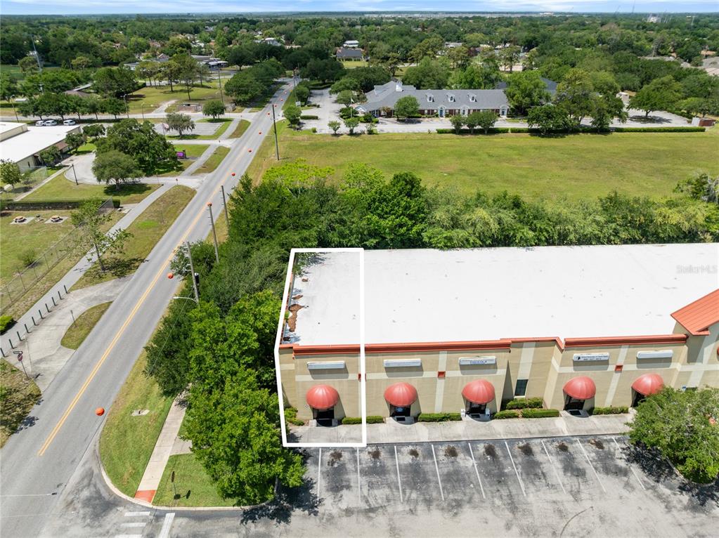 An aerial view shows a commercial building with a highlighted unit and adjacent parking lot — 3000 17TH STREET, ST CLOUD, FL