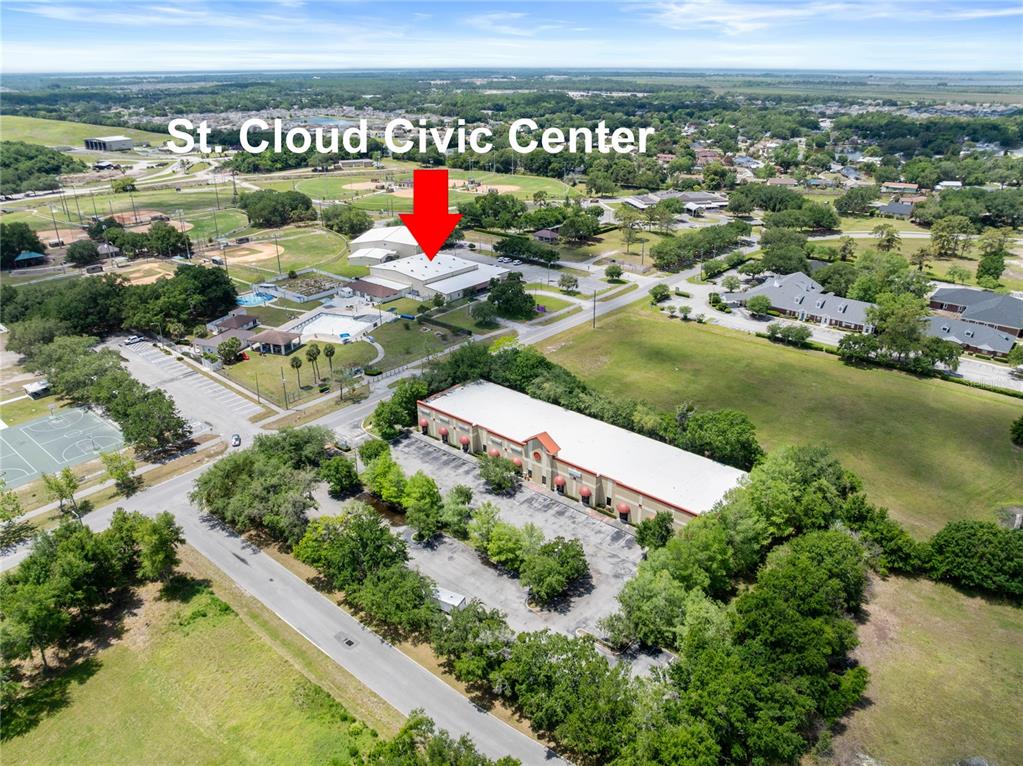 An aerial view shows a civic center building, a nearby commercial structure, and surrounding parkland — 3000 17TH STREET, ST CLOUD, FL