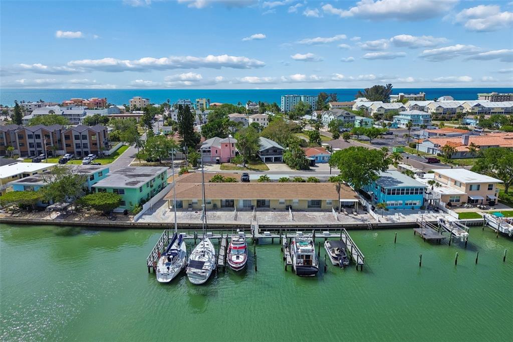 An aerial view shows a waterfront apartment building with a private dock and several boats — 2307 BAY BOULEVARD, INDIAN ROCKS BEACH, FL