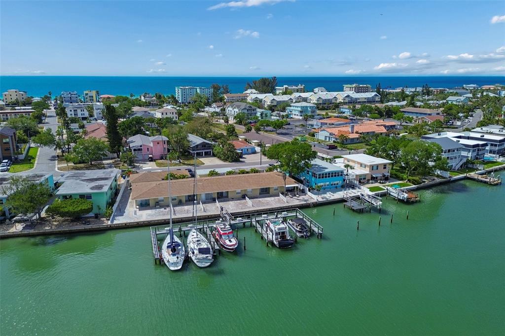 An aerial view shows a waterfront apartment building with a private dock and several boats — 2307 BAY BOULEVARD, INDIAN ROCKS BEACH, FL
