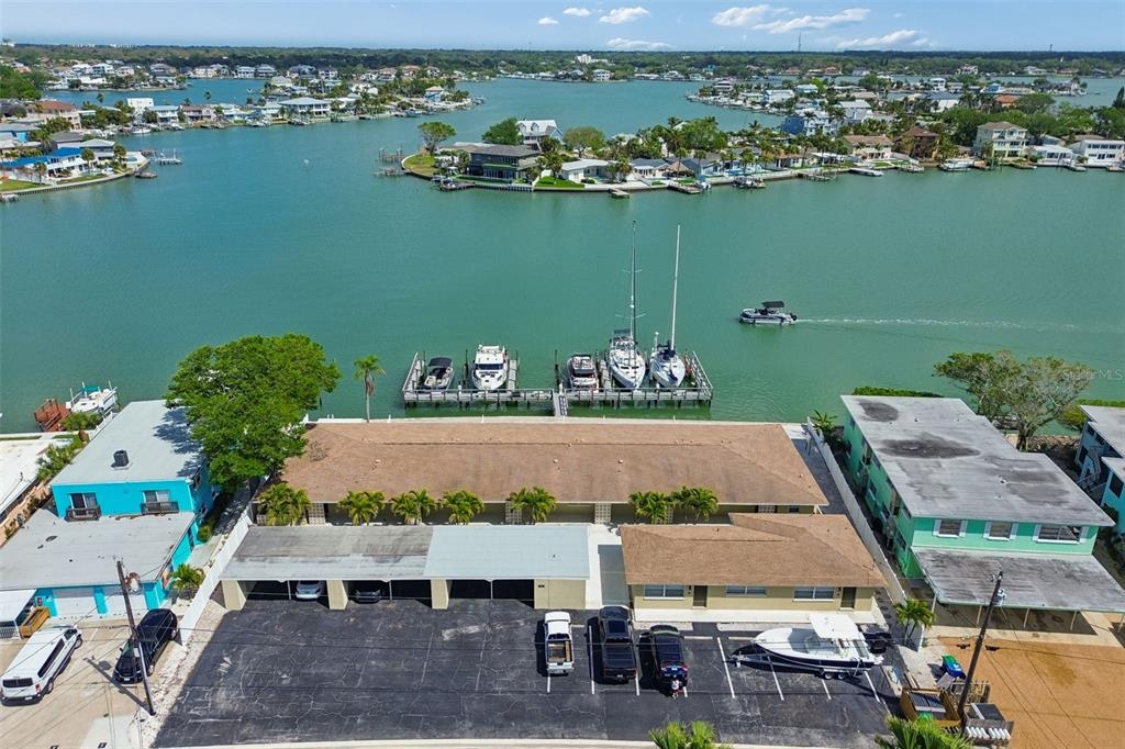 An aerial view shows a waterfront apartment building with a parking lot and boat slips — 2307 BAY BOULEVARD, INDIAN ROCKS BEACH, FL