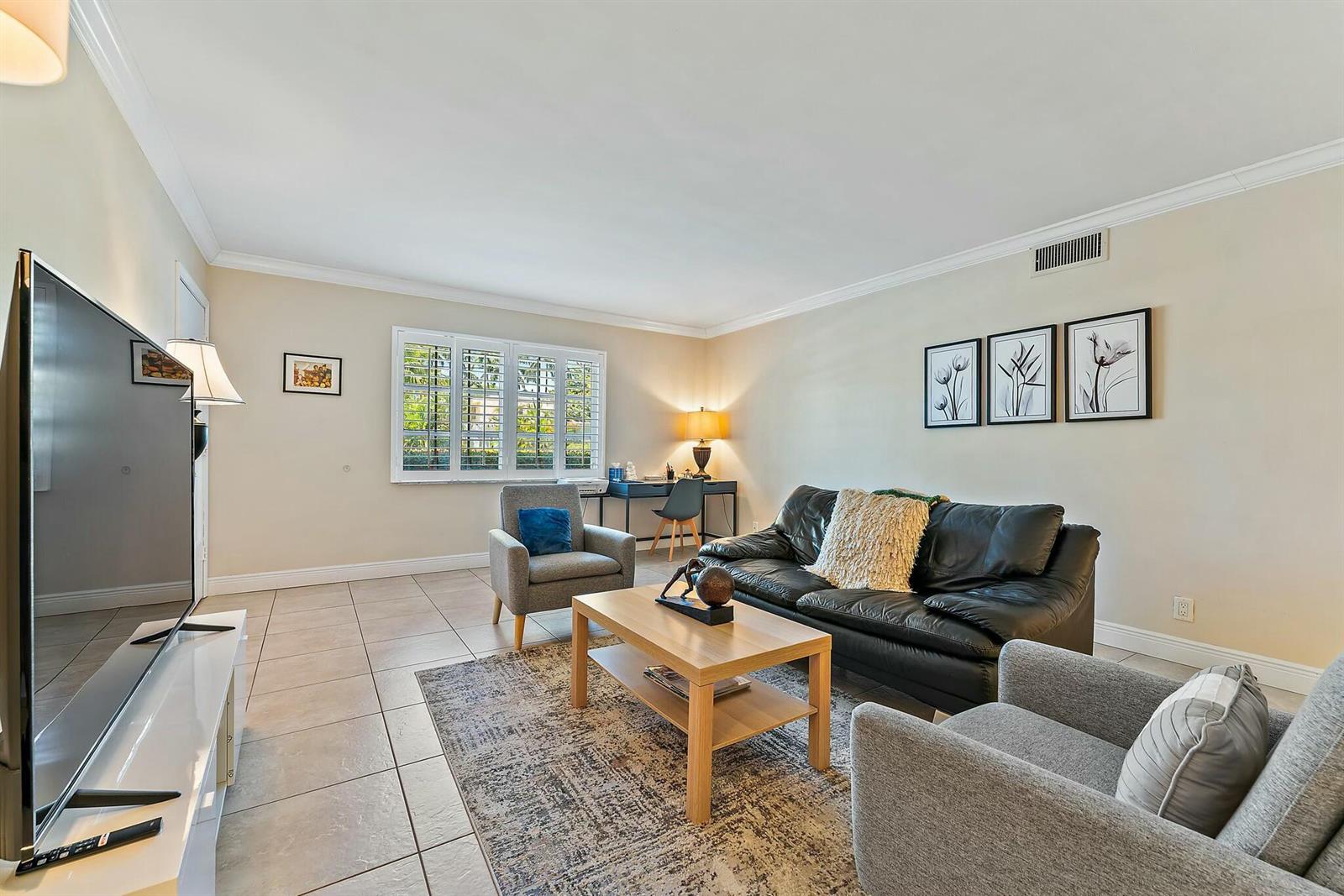 A living room features a black leather sofa, two gray armchairs, and tile flooring — 3036 Park Avenue, Riviera Beach FL 33404, RIVIERA BEACH, FL