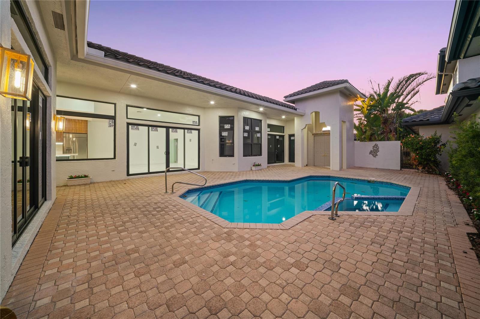 A backyard patio features a swimming pool, brick pavers, and large glass sliding doors — 22722 El Dorado Drive, Boca Raton FL 33433, BOCA RATON, FL