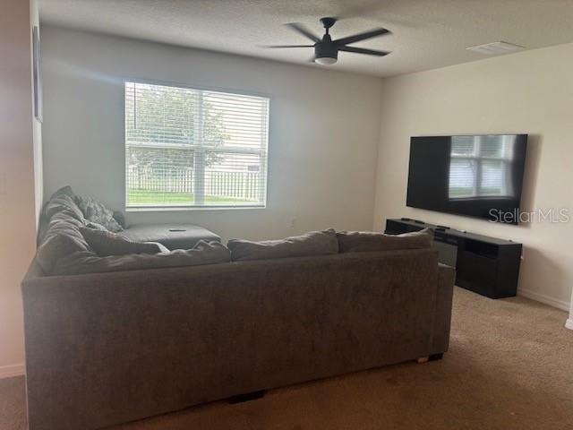 A living room features a large sectional sofa, a wall-mounted television, and a ceiling fan — 32696 PEZ LANDING LANE, WESLEY CHAPEL, FL