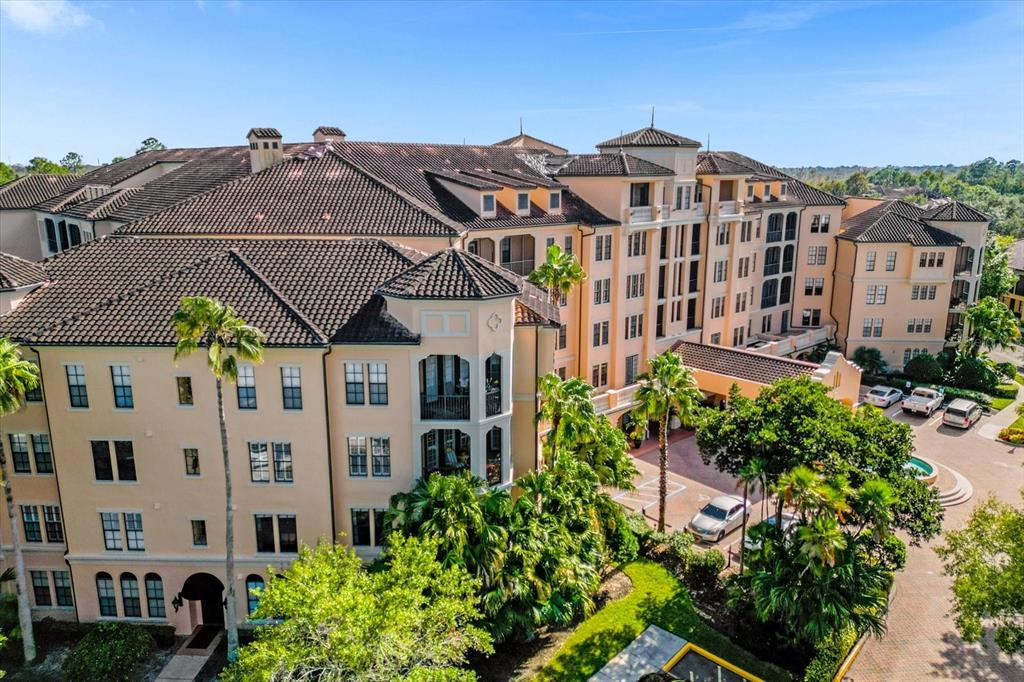 An aerial view of a multi-story, Mediterranean-style apartment building with a tiled roof — 501 MIRASOL CIRCLE UNIT 208, CELEBRATION, FL