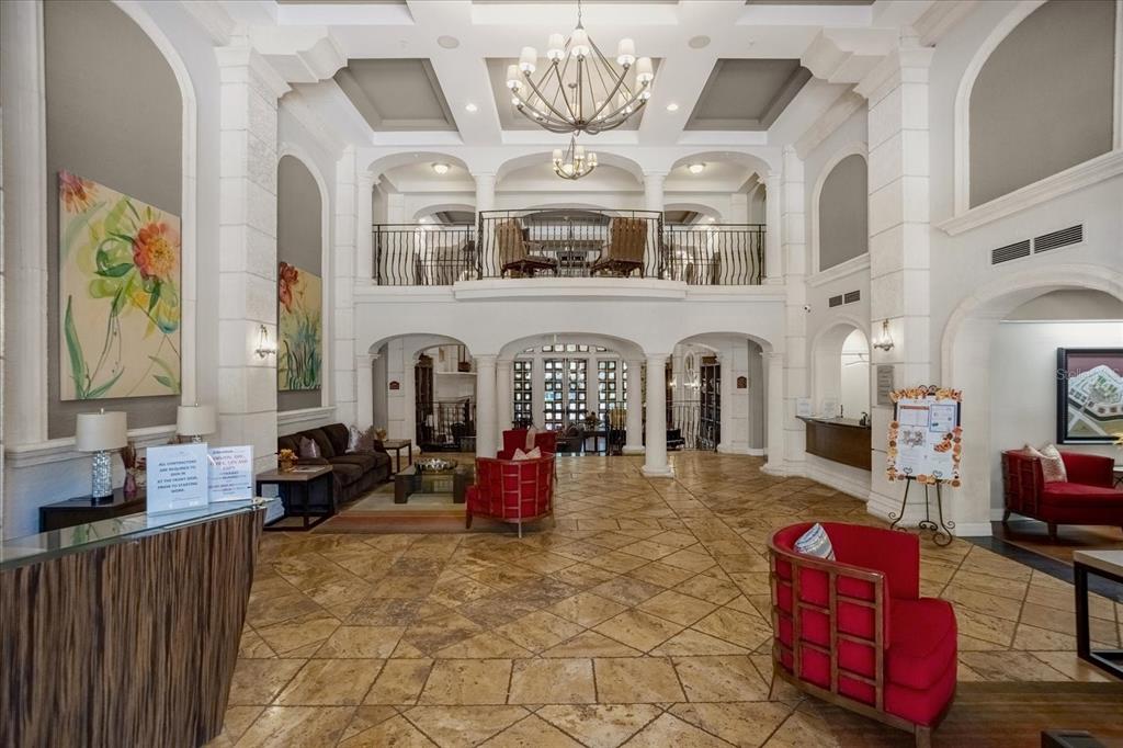 A spacious lobby features a high ceiling, stone tile floors, and a second-floor balcony — 501 MIRASOL CIRCLE UNIT 208, CELEBRATION, FL