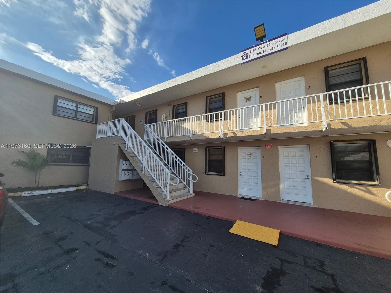 An exterior view of a two-story apartment building with an outdoor staircase and parking area — 1185 W 27th St, Hialeah FL 33010, HIALEAH, FL