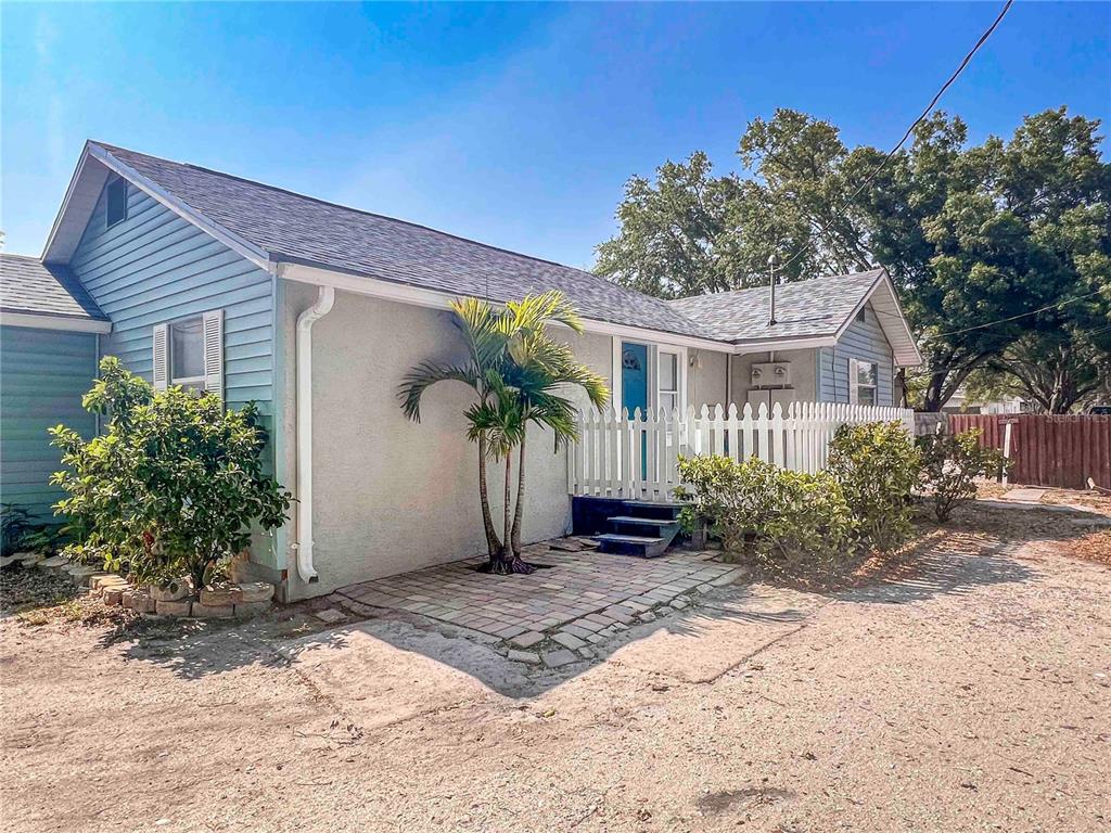 A single-story house with light blue siding, a stucco section, and a small brick patio — 2137 ROSELAWN STREET UNIT A, SARASOTA, FL