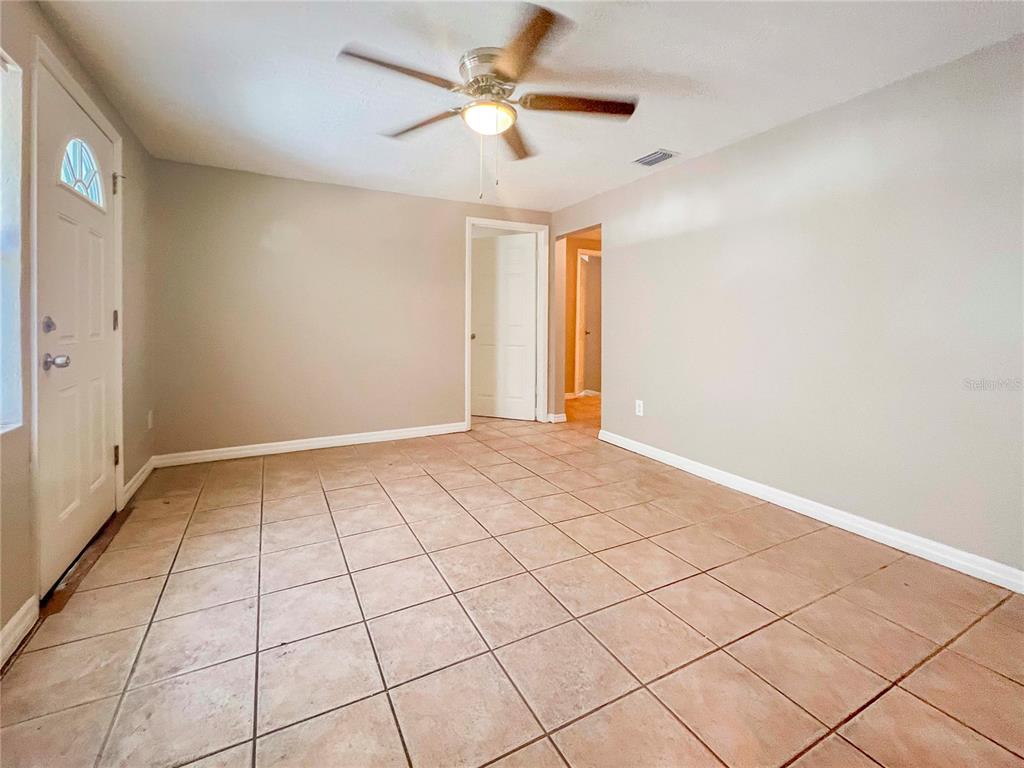 An empty room with beige walls, a ceiling fan, and light-colored tile flooring — 2137 ROSELAWN STREET UNIT A, SARASOTA, FL