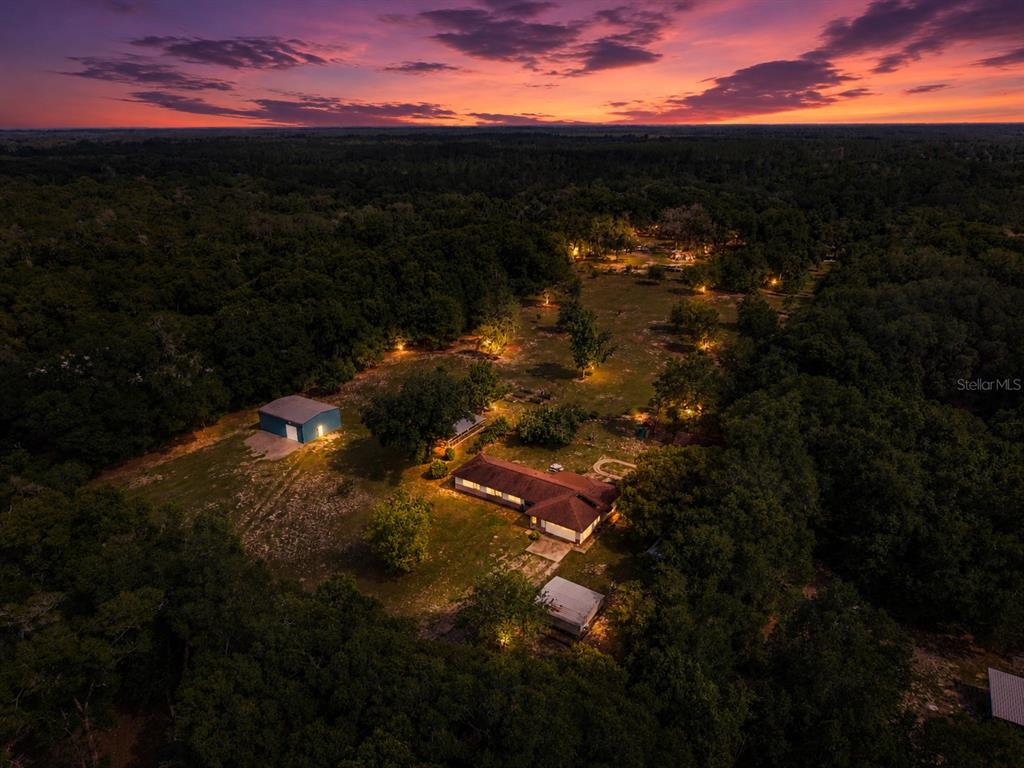 An aerial view shows a house and a detached garage on a wooded rural lot — 1167 OHIO STREET, DE LEON SPRINGS, FL