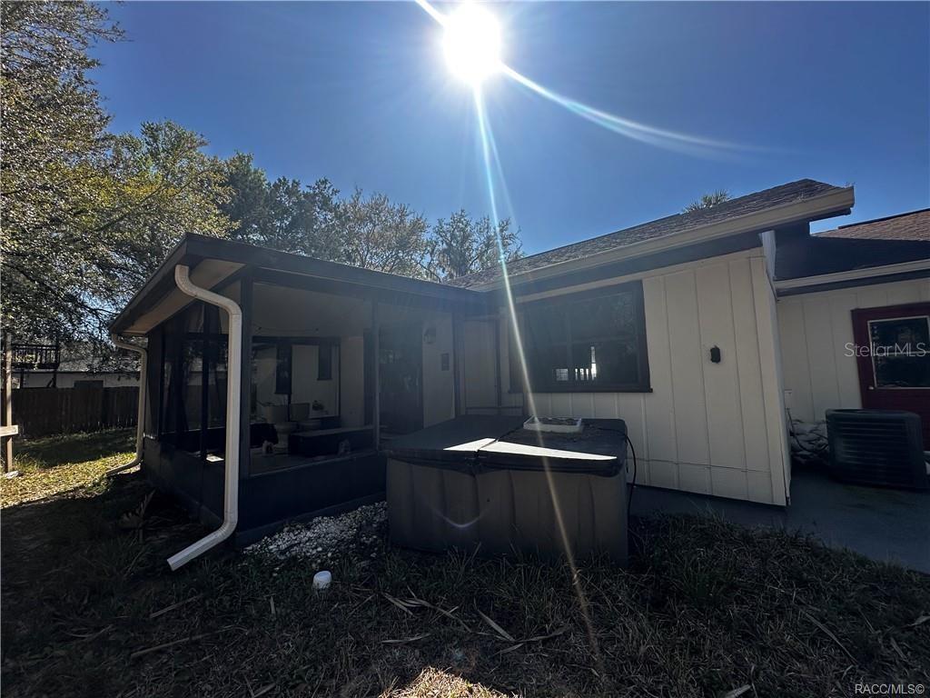 The exterior of a house features a screened-in porch and a hot tub — 4197 N CONCORD DRIVE, CRYSTAL RIVER, FL