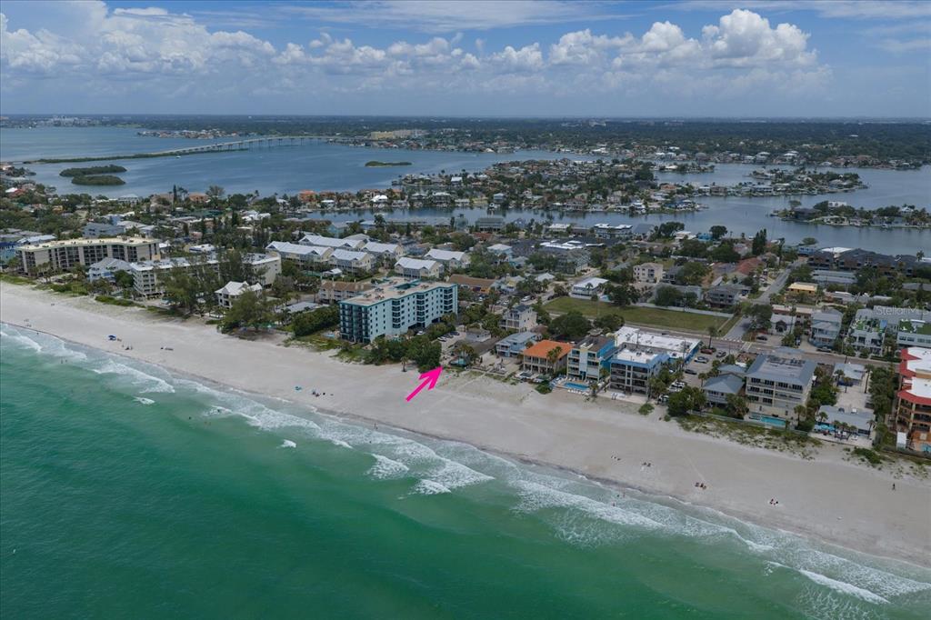 An aerial view of a beachside property with a pink arrow pointing toward the building — 2308 BEACH TRAIL, INDIAN ROCKS BEACH, FL