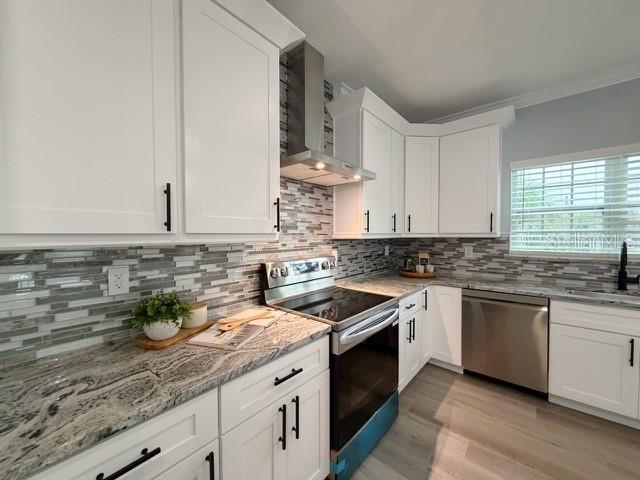 A modern kitchen features white cabinets, granite countertops, a stainless steel stove, and tiled backsplash — 1083 S POINTE ALEXIS DRIVE, TARPON SPRINGS, FL