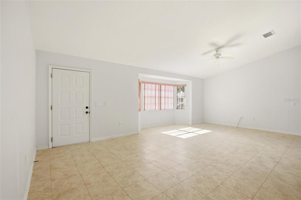 A single-story house with a white exterior, a two-car garage, and a curved concrete driveway — 4201 LOQUAT ROAD, SEBRING, FL