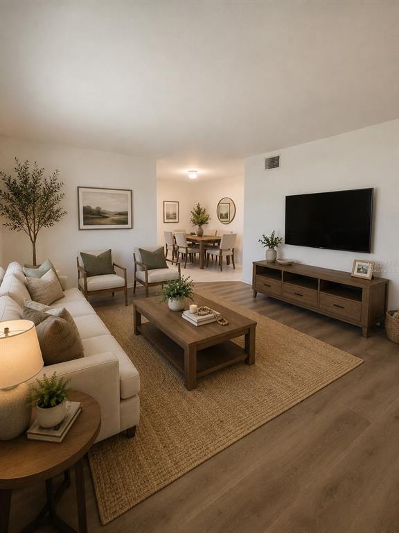 A living room features a beige sofa, two armchairs, a coffee table, and a television — 1700 6TH STREET NW UNIT A38, WINTER HAVEN, FL