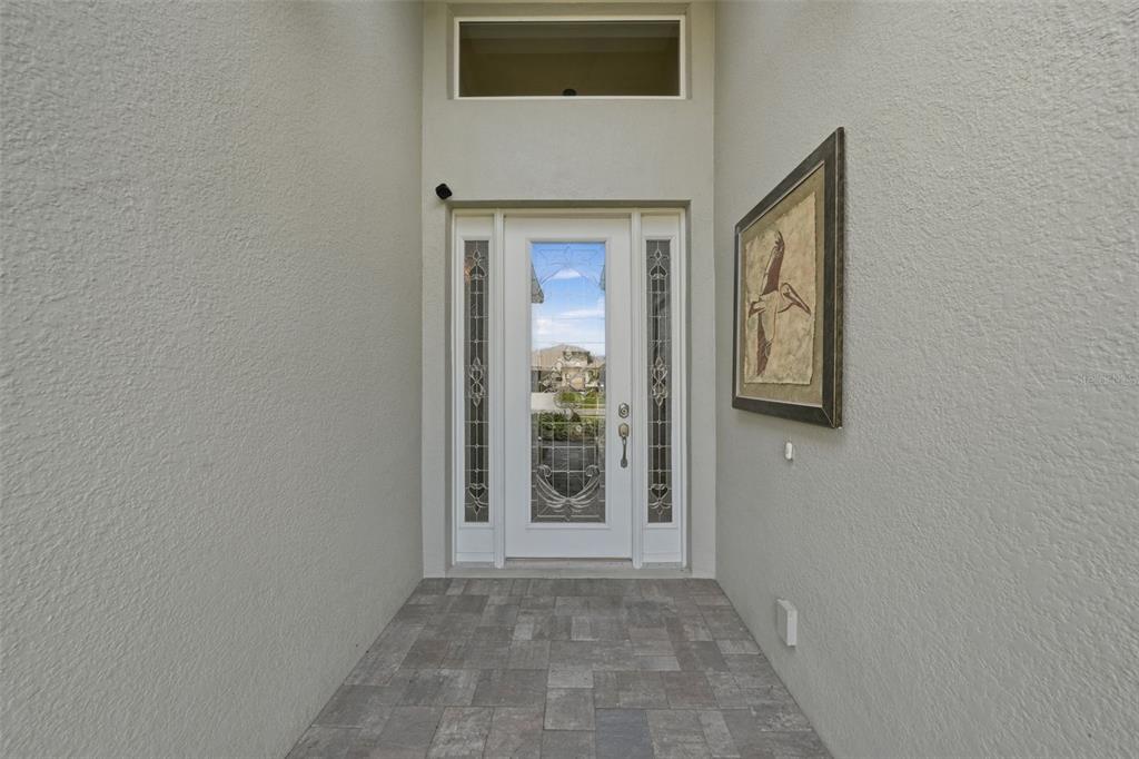 A front entryway features a white door with glass inserts, side lights, and a transom window — 8732 PROVIDENCE COURT, MOUNT DORA, FL