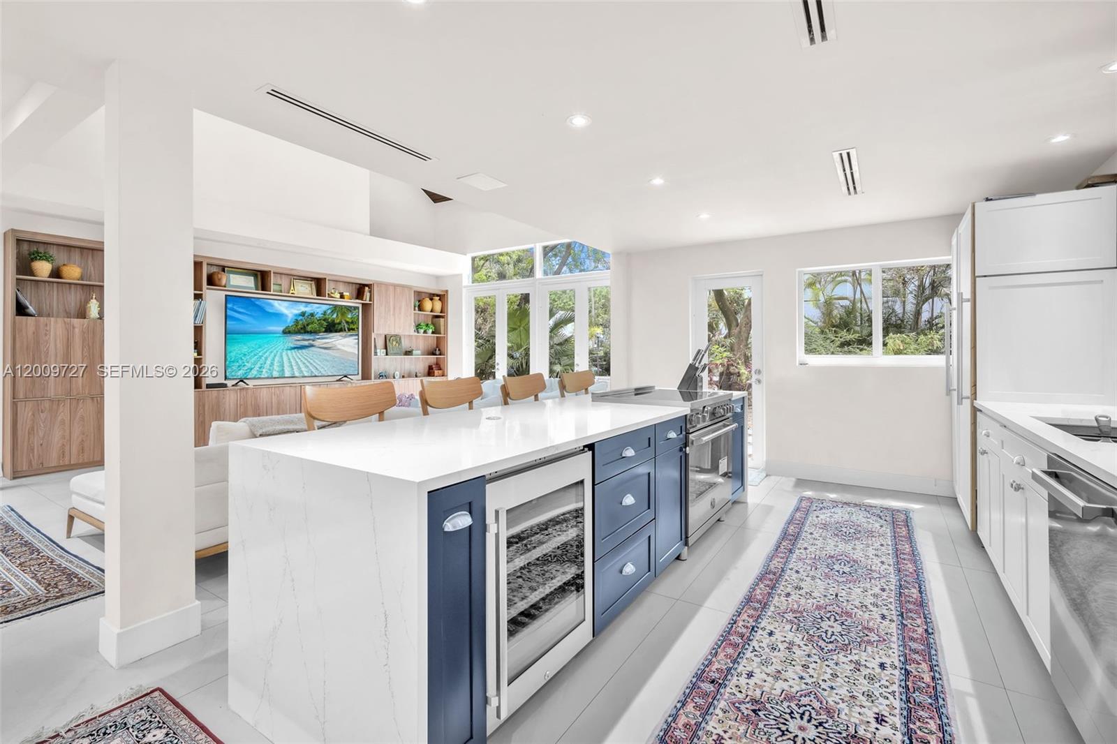 A modern kitchen features a blue island with a wine cooler and white countertops — 1933 S Oak Haven Cir, Miami FL 33179, MIAMI, FL