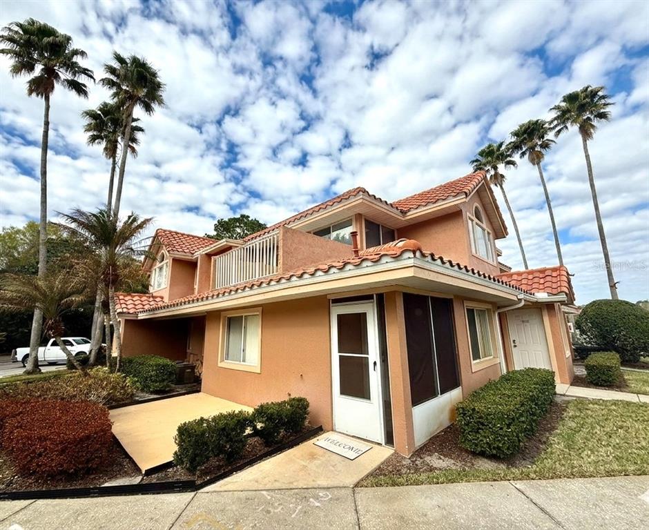 A two-story stucco townhouse with a red tile roof and a screened-in front porch — 5202 WATERVIEW WAY UNIT 5202, WINTER HAVEN, FL