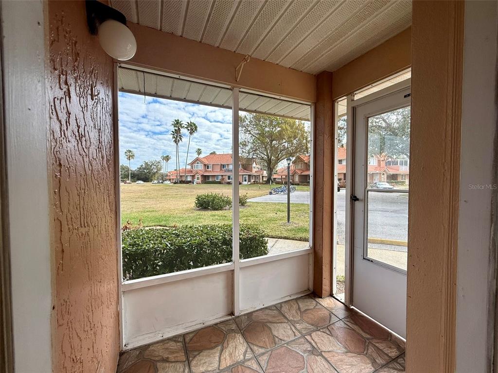 A screened-in porch features a tiled floor, a light fixture, and views of a grassy area — 5202 WATERVIEW WAY UNIT 5202, WINTER HAVEN, FL