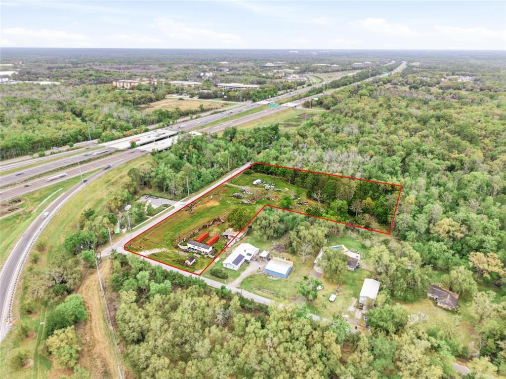 An aerial view shows a rural property outlined in red next to a highway — 9014 122ND AVENUE, TAMPA, FL