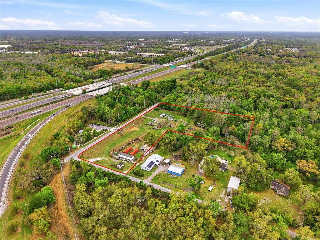 An aerial view shows a rural property outlined in red near a highway — 9014 122ND AVENUE, TAMPA, FL