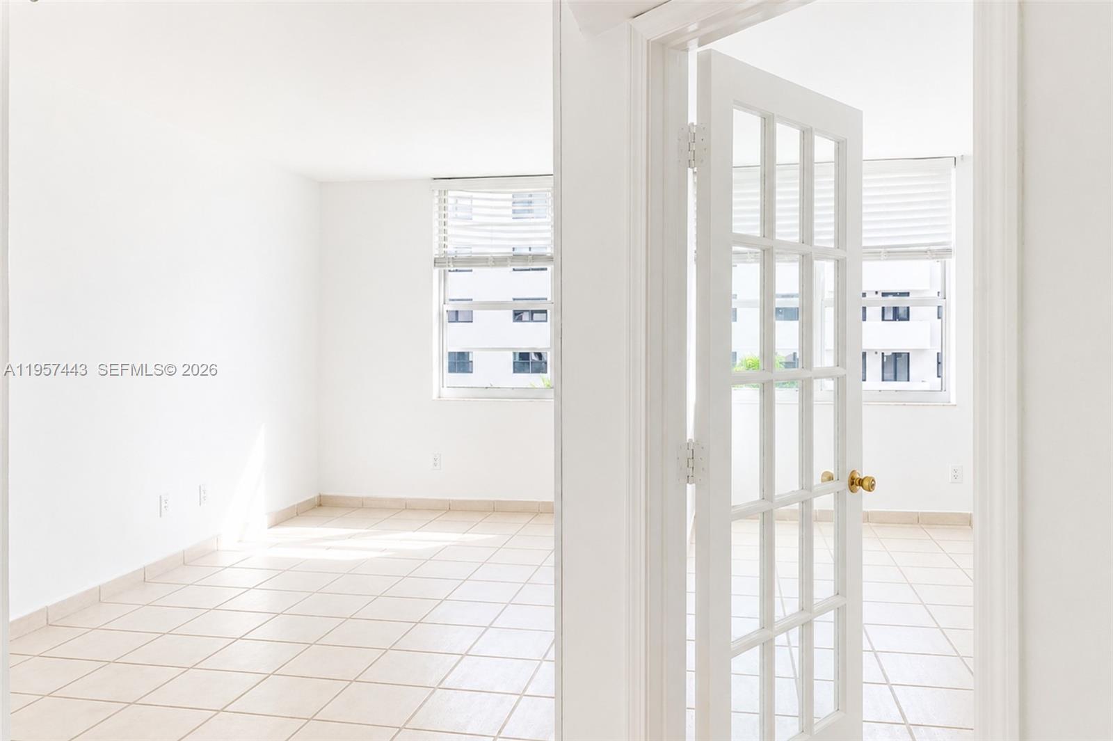 An interior view shows a white room with tiled floors and a French door — 100 Lincoln Rd # 732, Miami Beach FL 33139, MIAMI BEACH, FL