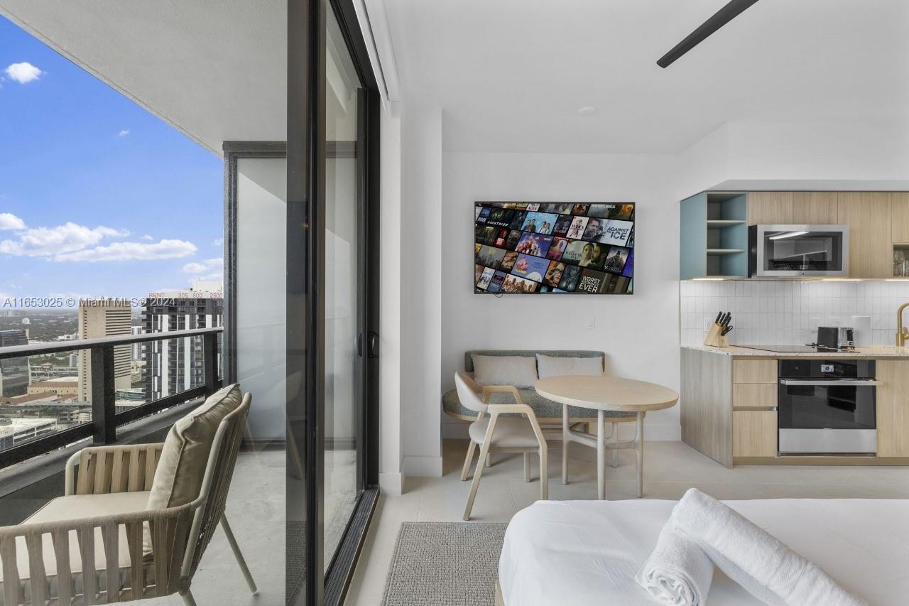 A studio apartment features a kitchenette, a small dining area, and a balcony with city views — 601 NE 1 # 4410, Miami FL 33132, MIAMI, FL