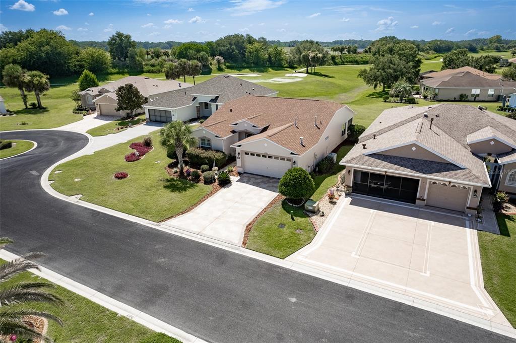 An aerial view shows three suburban houses with driveways and lawns bordering a golf course — 15541 SW 11TH TERRACE ROAD, OCALA, FL