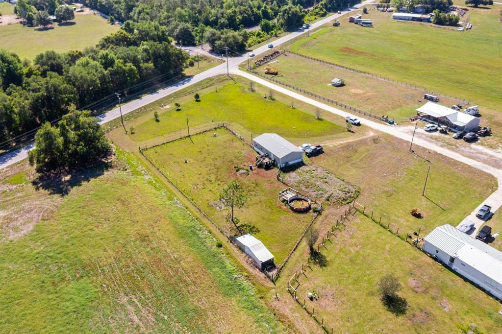An aerial view shows a rural property with a house, outbuildings, and fenced yard — 12011 OLD LAKELAND HIGHWAY, DADE CITY, FL