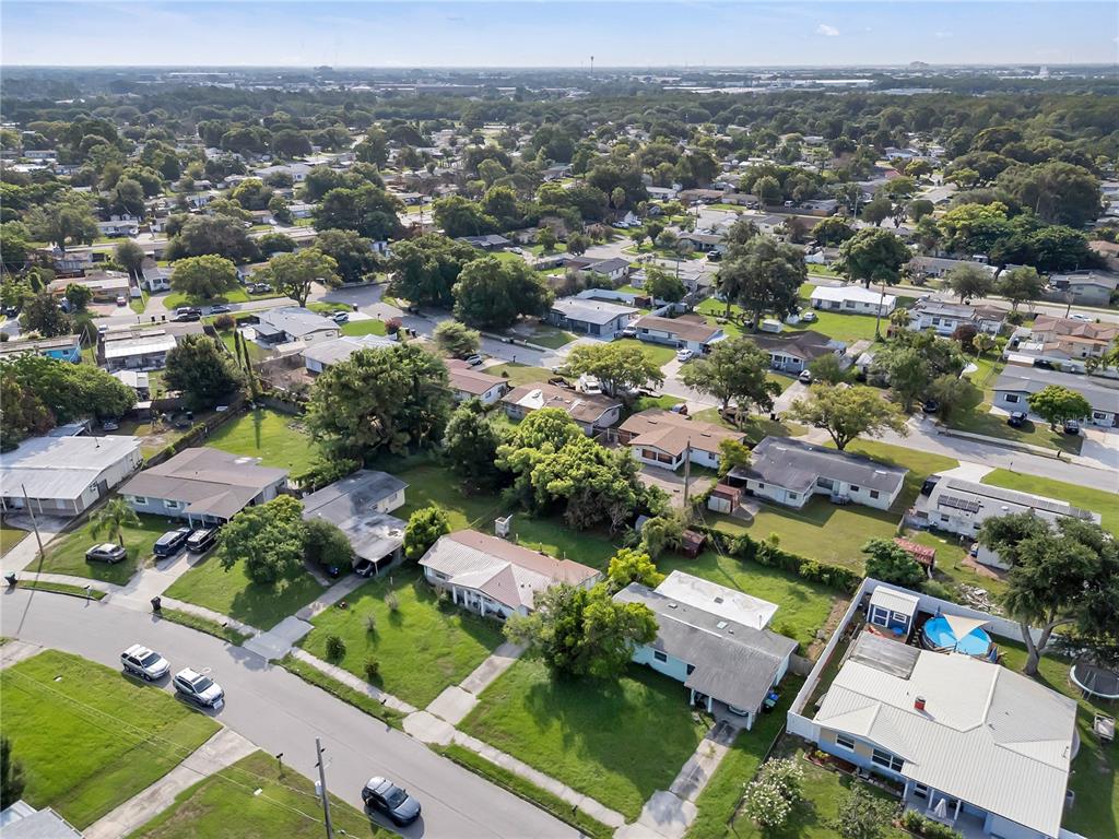 An aerial view shows a suburban neighborhood with single-story houses, green lawns, and streets — 6201 ANTILLA DRIVE, ORLANDO, FL