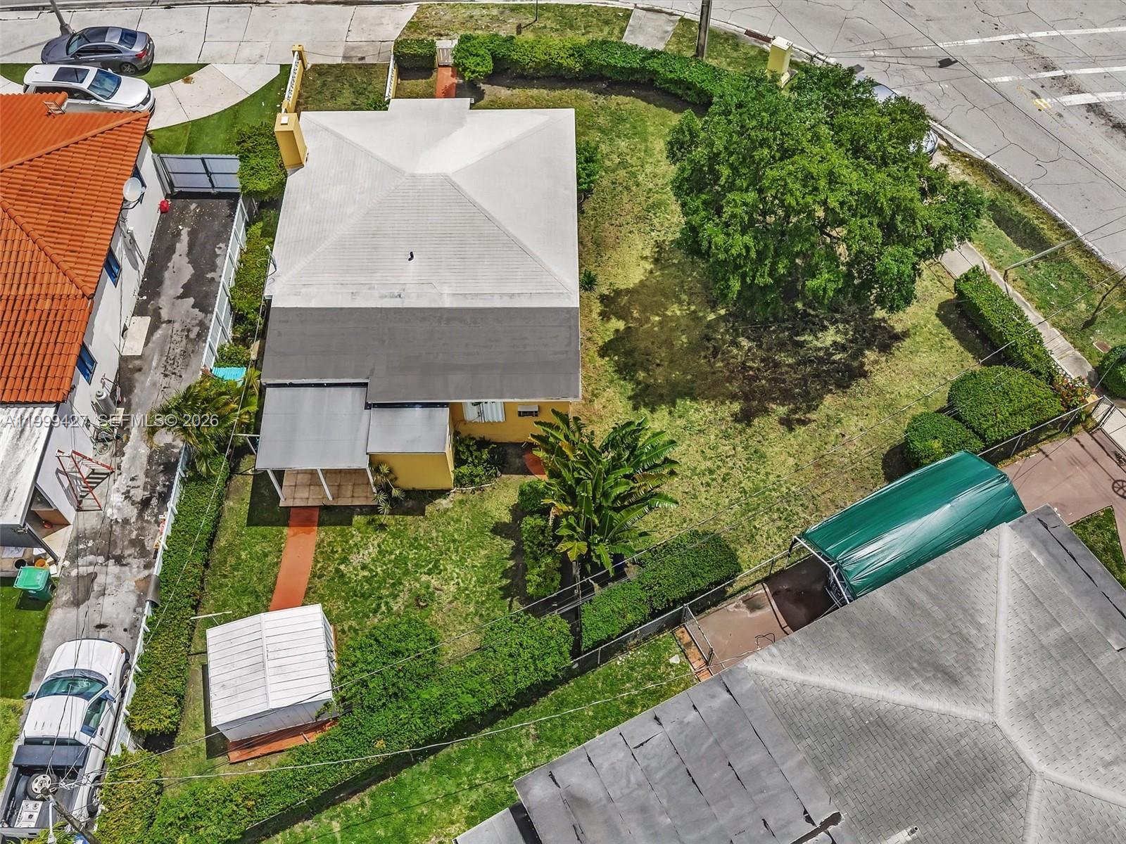 An aerial view shows a yellow house with a white roof, large yard, and trees — 10 SW 72nd Ave, Miami FL 33144, MIAMI, FL