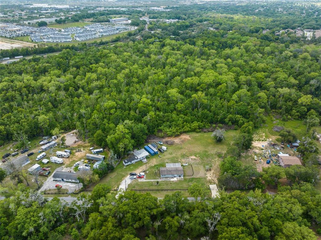 An aerial view shows a rural property with two houses surrounded by dense forest — 16838 OLD HIGHWAY 50, WINTER GARDEN, FL