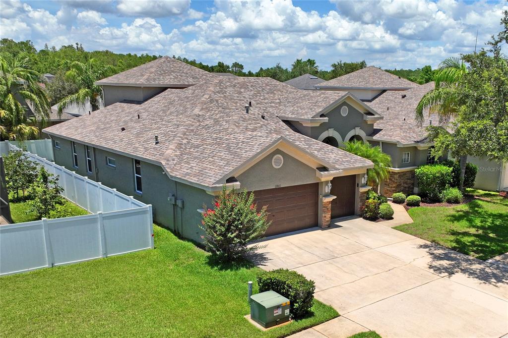 An aerial view of a suburban house with a multi-gabled roof and a concrete driveway — 12801 STANWYCK CIRCLE, TAMPA, FL
