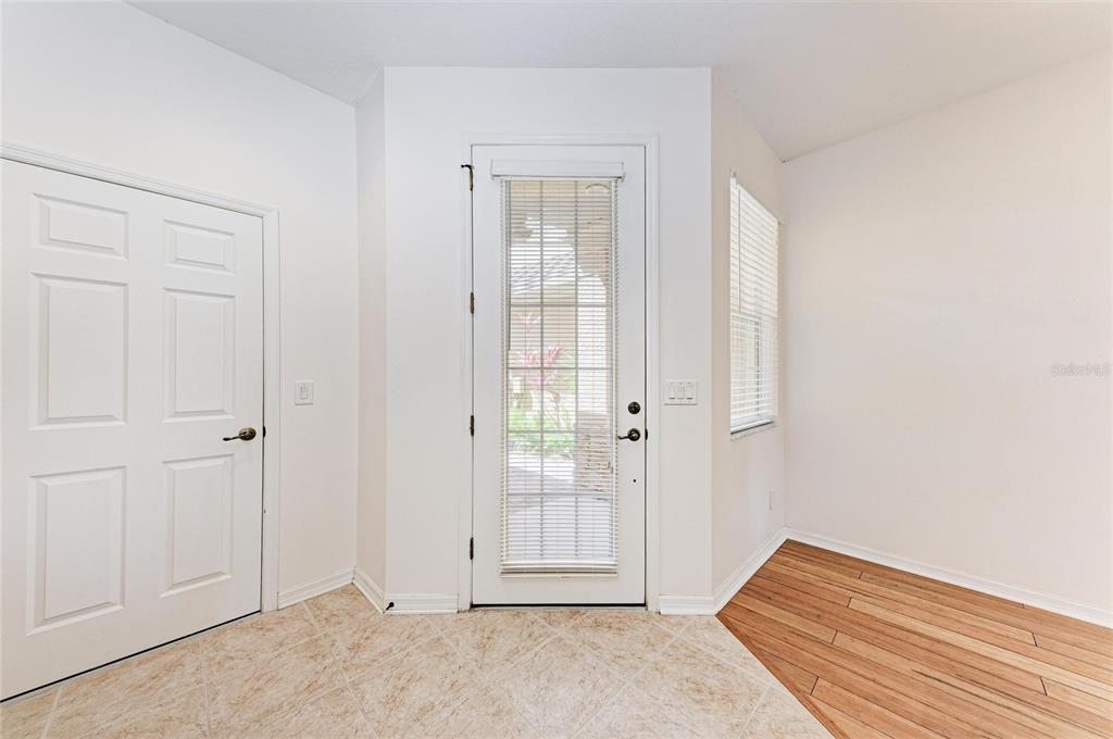 An entryway features a white door with a window, tile flooring, and wood-look flooring — 8160 VILLA GRANDE CT, SARASOTA, FL