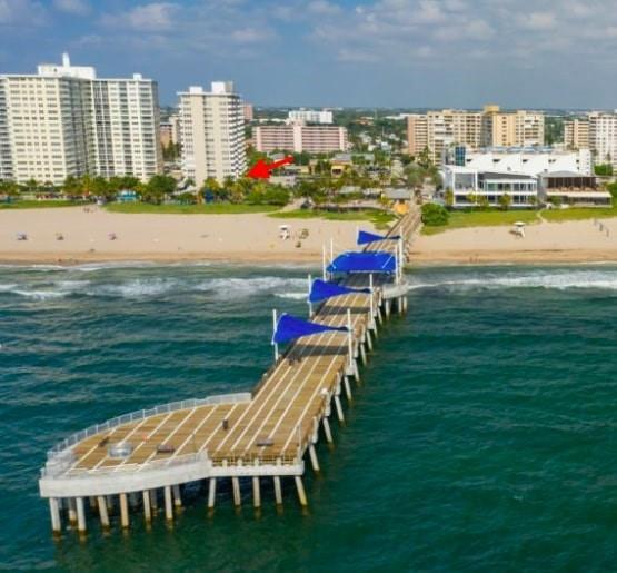 An aerial view of a wooden pier extending into the ocean toward a sandy beach — 133 N Pompano Beach Boulevard # 210, Pompano Beach FL 33062, POMPANO BEACH, FL