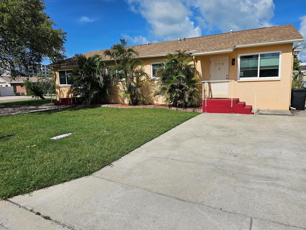 A single-story peach-colored house with a concrete driveway and red steps leading to the entrance — 175 174TH TERRACE DRIVE E UNIT 2, REDINGTON SHORES, FL