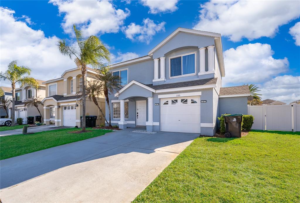 A two-story light blue house with a white garage and a concrete driveway — 1186 SANDESTIN WAY, ORLANDO, FL