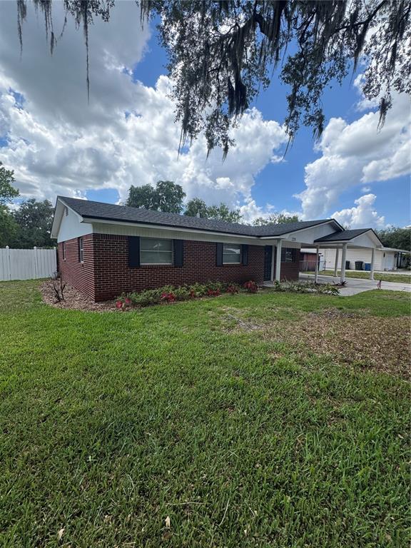 A single-story brick house with a dark shingled roof and an attached carport — 2255 E HELEN CIRCLE, BARTOW, FL