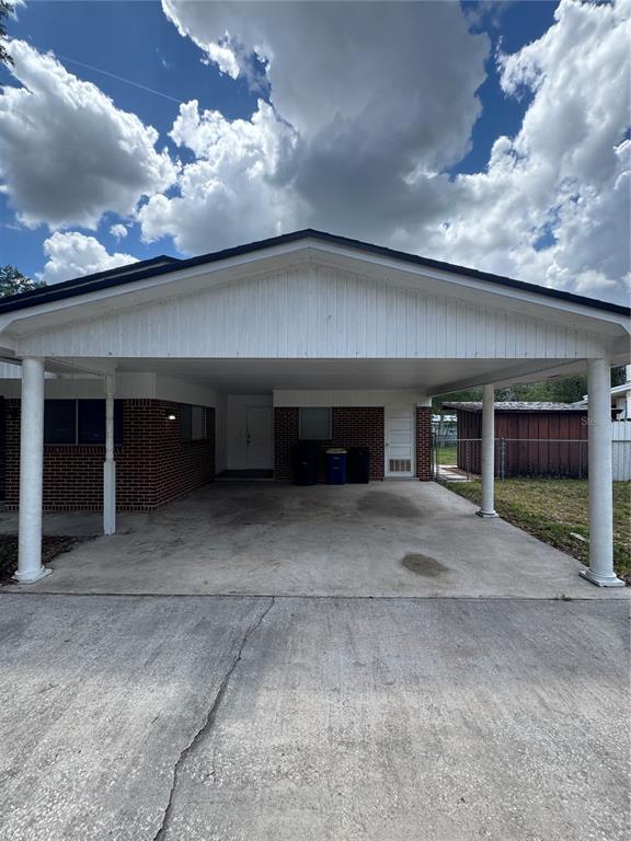 A concrete driveway leads to a covered carport attached to a brick residential building — 2255 E HELEN CIRCLE, BARTOW, FL