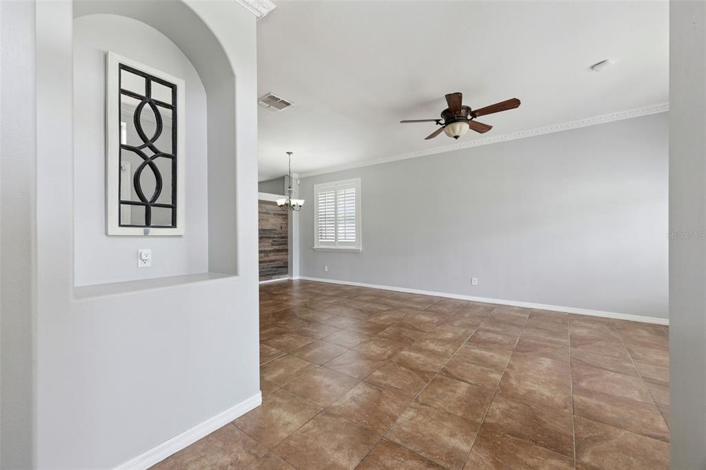An interior view of a living area with tiled floors, a ceiling fan, and an alcove — 14580 SAINT GEORGES HILL DRIVE, ORLANDO, FL