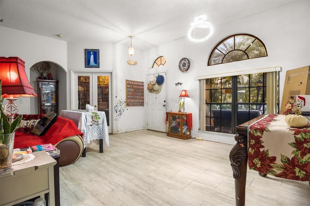 A living room features light tile flooring, a red sofa, and a large arched window — 428 COVENTRY ROAD, DAVENPORT, FL