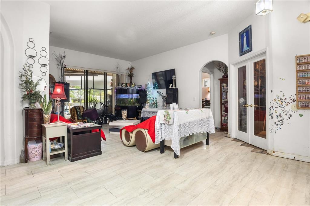 A living room with light tile flooring, a large fish tank, and a glass door — 428 COVENTRY ROAD, DAVENPORT, FL