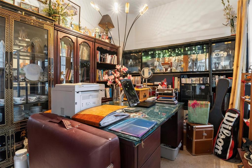 A home office features a glass-topped desk, dark wood cabinetry, and a tall floor lamp — 428 COVENTRY ROAD, DAVENPORT, FL