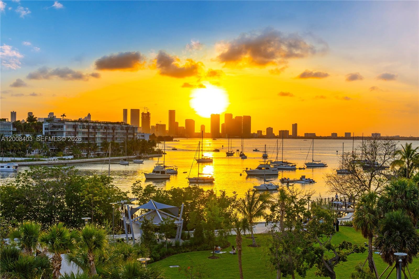 A sunset view over a bay with boats, a park, and a distant city skyline — 1701 Sunset Harbour Dr # L501, Miami Beach FL 33139, MIAMI BEACH, FL