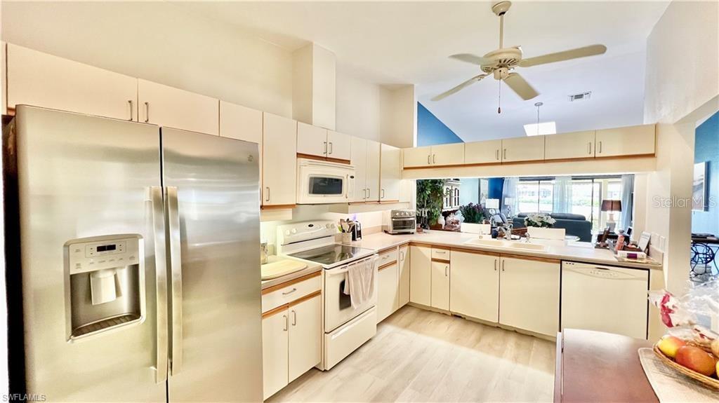 A kitchen features white cabinets, stainless steel appliances, and a ceiling fan over the space — 1640 ATARES DRIVE UNIT 31, PUNTA GORDA, FL