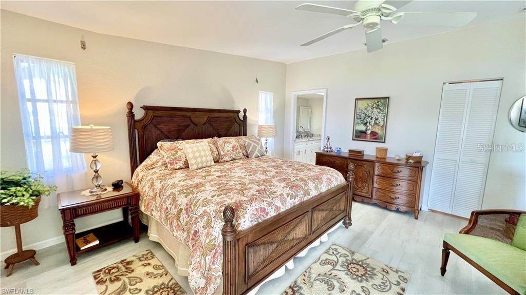 A bedroom features a wooden bed frame, a dresser, and a ceiling fan — 1640 ATARES DRIVE UNIT 31, PUNTA GORDA, FL