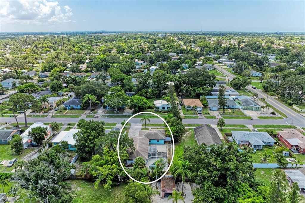 An aerial view shows a single-story house with a screened-in pool area and palm trees — 2508 14TH AVENUE W, BRADENTON, FL