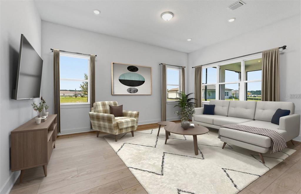 This is a virtual rendering of a living room with a sofa, armchair, and television — 13531 CANYON RIDGE ROAD, SPRING HILL, FL